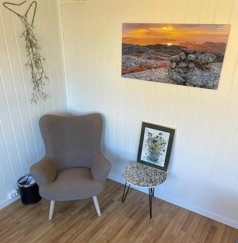a room with a chair and a table with a picture at Valldal Fjord Lodge B&B in Valldal