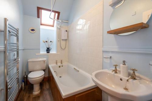 ein Badezimmer mit einem Waschbecken, einem WC und einer Badewanne in der Unterkunft The 'Fairy Hill' Apartment in Inverness
