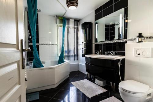 une salle de bain avec toilettes, baignoire et lavabo dans l'établissement Maison au calme, proche Paris et Disney, à Mitry-Mory