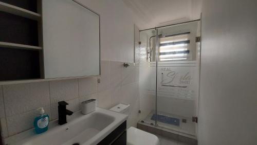 a bathroom with a sink and a glass shower at Lovely 1 & 2 Bed Apartment at RealShala Homes - East Legon Hills in East Legon