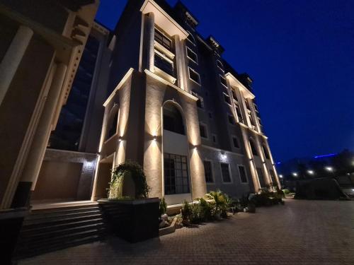 a building with a clock tower at night at Fontis Residences Hotel in Kampala