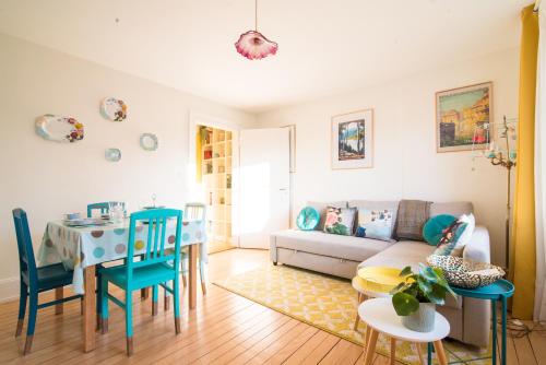 un salon avec un canapé, une table et des chaises dans l'établissement Maison 1934 - Colmar Gare & parking gratuit j, à Colmar