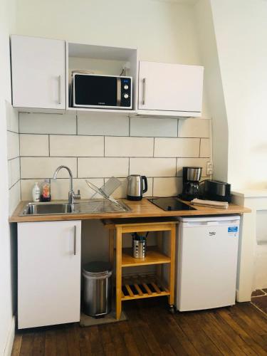 cocina con encimera con fregadero y microondas en Appartement T2 proche gare - DABNB, en Limoges