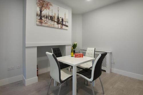 a dining room with a white table and chairs at 15 Selwyn Street, Luxury house in Liverpool