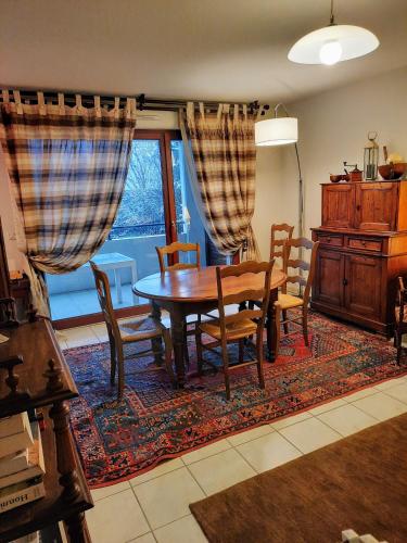 une salle à manger avec une table et des chaises et une fenêtre dans l'établissement Entre Lac d'Annecy et montagnes, golf et parapente à pieds, à Talloires