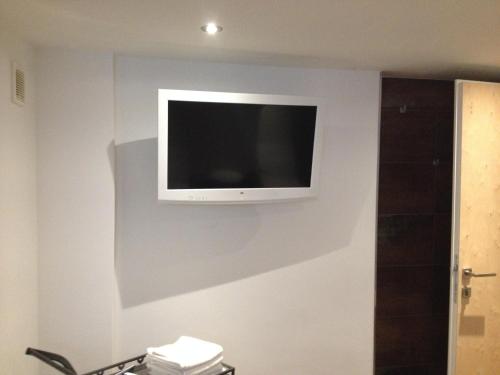 a flat screen tv on the wall of a bathroom at Apartpension Kappacher in Kaprun