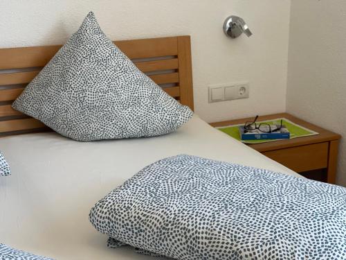 a bed with two pillows on top of it at Apart Kathrin in Fliess