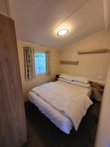 黑潭的住宿－Caravan Kensington 46 at Marton Mere Blackpool，一间卧室设有一张大床和一个窗户。