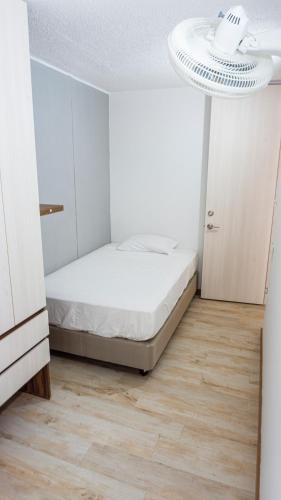 a white bedroom with a bed and a ceiling at LivinnX Barranquilla in Barranquilla
