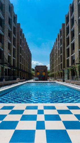 a large swimming pool in a city with tall buildings at LivinnX Barranquilla in Barranquilla