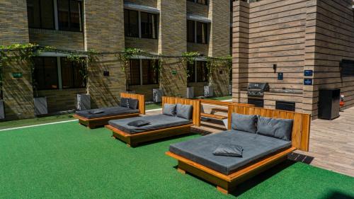 a patio with three couches on the grass at LivinnX Barranquilla in Barranquilla
