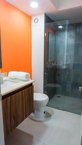 a bathroom with a toilet and a glass shower at LivinnX Barranquilla in Barranquilla