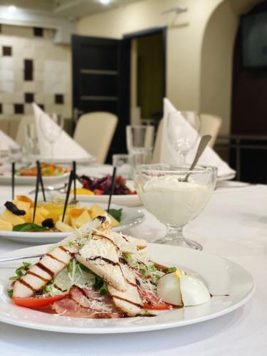 a table with plates of food and a bowl of cheese at Yavir in Poltava