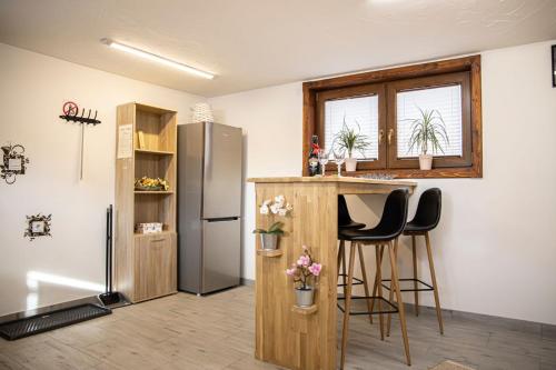 a kitchen with a refrigerator and a counter with stools at Olczański Gościniec apartament nr 1 in Zakopane