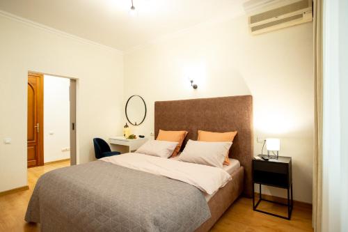 a bedroom with a bed and a desk and a mirror at Квартира в центре на соборной apartment in sobornaya st in Mykolaiv