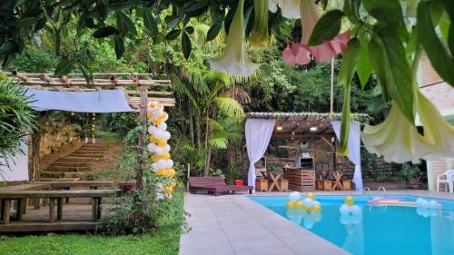 un locale a bordo piscina con tavolo, sedie e piscina di Residencial Dona Francisca a Florianópolis