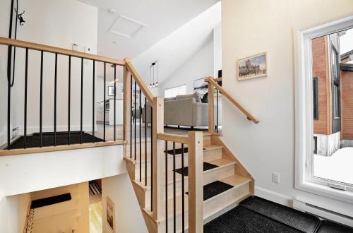 a staircase in a home with white walls and a window at 100 Chemin des Ruisselets in Stoneham