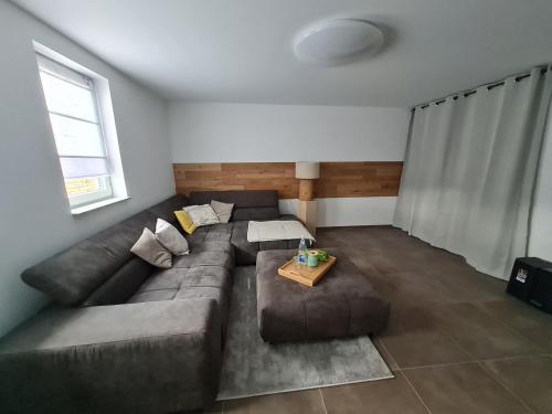 a living room with a brown couch and a table at Meet & Greet am Radfernweg E-Bike modern in Erfurt