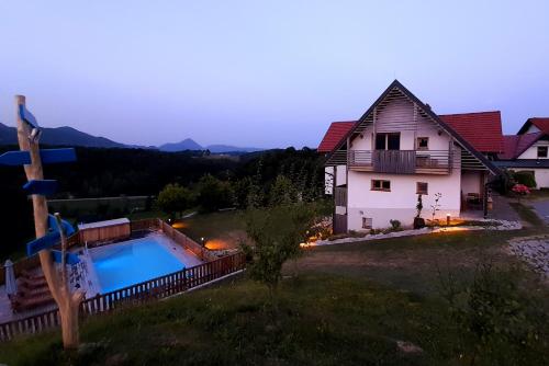 a house with a swimming pool in front of a house at Relax Guest Hause Marjanca in Rogaška Slatina