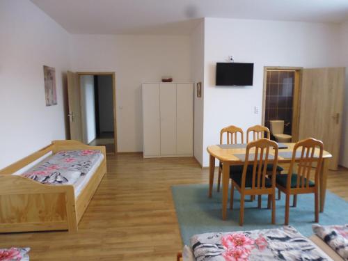 a living room with a table and chairs and a bed at Penzion Kelčany u Kyjova in Kelčany