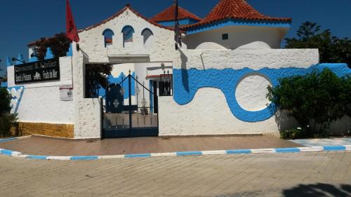 a blue and white building with a clock on it at Hotel Al Khaima in Asilah