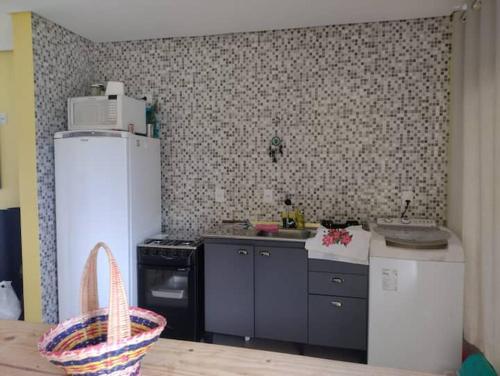 a kitchen with a refrigerator and a stove top oven at Casa de Praia a 550m da praia de Balneário Rosa do Mar e 350m da Lagoa da Tapera. in Passo de Torres