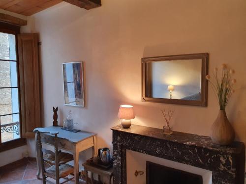 a living room with a fireplace and a mirror at La Maison Provençale in La Roquebrussanne