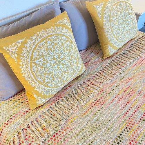 two pillows sitting on top of a bed at The Beachhouse Apartments in Vaia