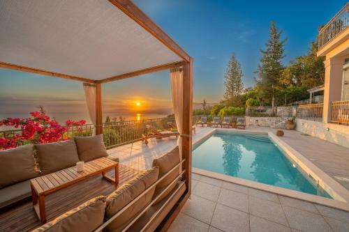 a backyard with a swimming pool and a gazebo at Luxury villa above emblisi beach , with heated pool ! in Fiskardho