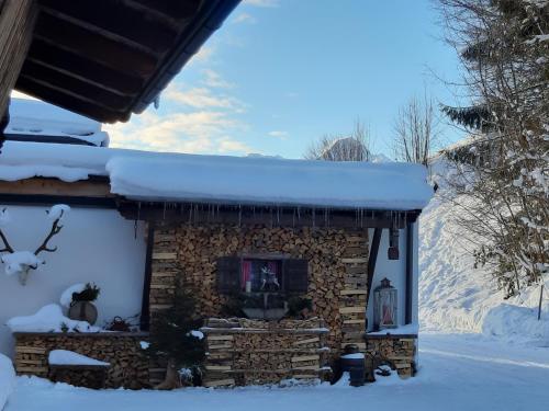 a log cabin with a fireplace in the snow at Haus Wildschütz in Hippach