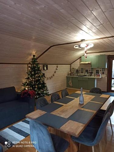 a dining room with a table and a christmas tree at Сімейний Затишок апартаменти in Oryavchyk