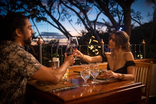 a man and woman sitting at a table with wine glasses at Hacienda Guachipelin Volcano Ranch Hotel & Hot Springs in Liberia