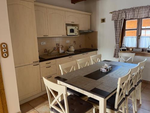 a kitchen with a table and chairs in a room at Apartmán Javorník a Javorníček in Velké Karlovice