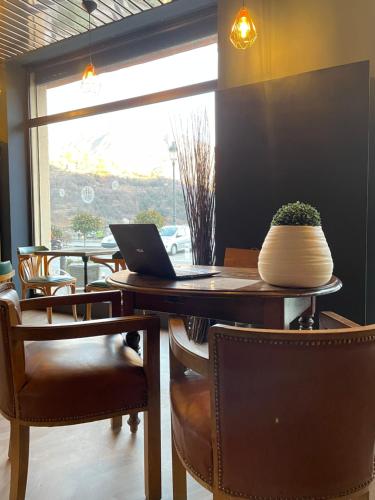 a dining room with a table with a laptop on it at Ostan Hôtel Boutique in Roquebillière