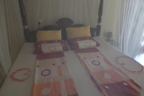 uma cama com duas almofadas e um cobertor em Mallis Guesthouse em Habaraduwa Central