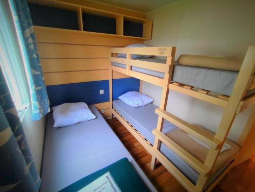 Cette petite chambre comprend 2 lits superposés et un ordinateur portable. dans l'établissement Mobil-Home Cosy 5 personnes camping le Ried - Europapark, à Boofzheim