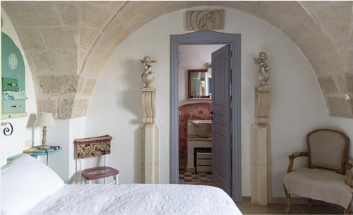 a bedroom with a bed and a chair at Masseria Montenapoleone in Fasano