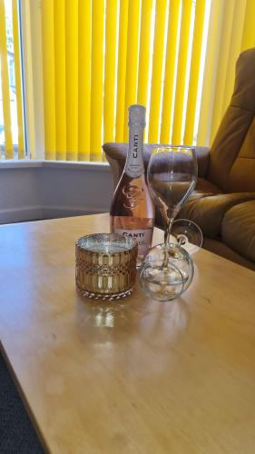 Fairoak Lodge في نيوبورت: زجاجة من الكحول وكأس النبيذ على الطاولة