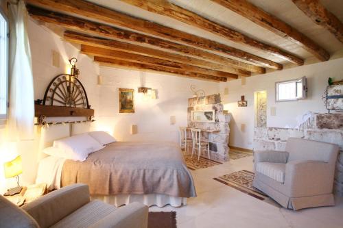 a bedroom with a bed and two chairs in a room at Masseria Montenapoleone in Fasano