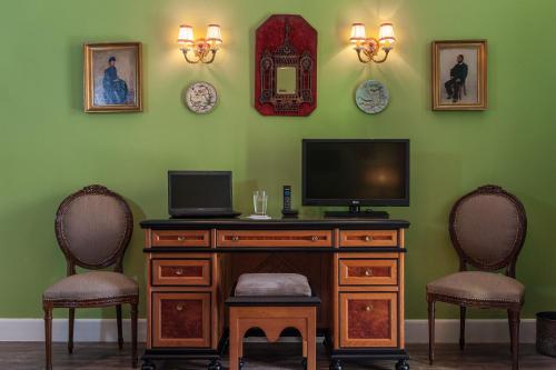 a living room with a television and two chairs at La Maison Ottomane in Chania Town