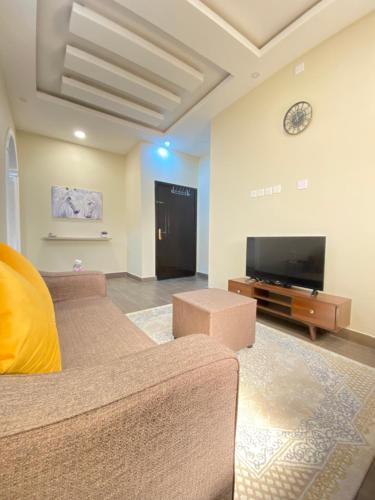 een woonkamer met 2 banken en een flatscreen-tv bij الأراضي السبع in Yanbu