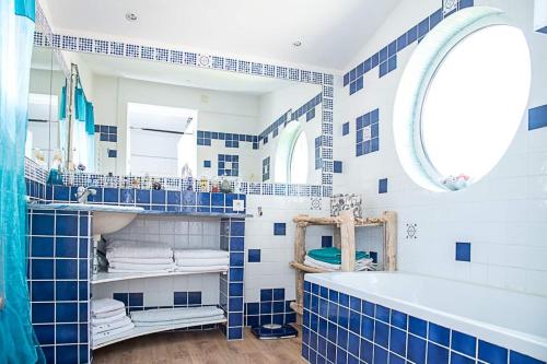 un bagno blu e bianco con vasca e lavandino di Mas Catalan avec piscine 12 à 15 personnes ad Argelès-sur-Mer