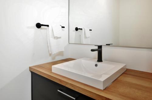 Un baño con un lavabo blanco y un espejo. en 17 Chemin des Cascades, en Stoneham