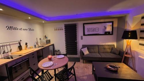 a living room with a couch and a table with chairs at Mille et une nuit, appartement classé 3 étoiles en RDC avec exterieur et parking in Dole