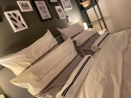 a hospital bed with white sheets and pillows at Mille et une nuit, appartement classé 3 étoiles en RDC avec exterieur et parking in Dole