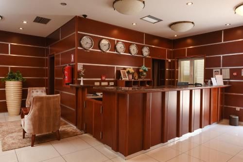 a lobby with wood paneling and a bar with clocks on the wall at Family Hotel Zanè in Pag