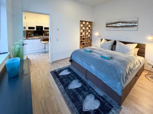 a bedroom with a large bed and a kitchen at Apartment am Landtag in Erfurt