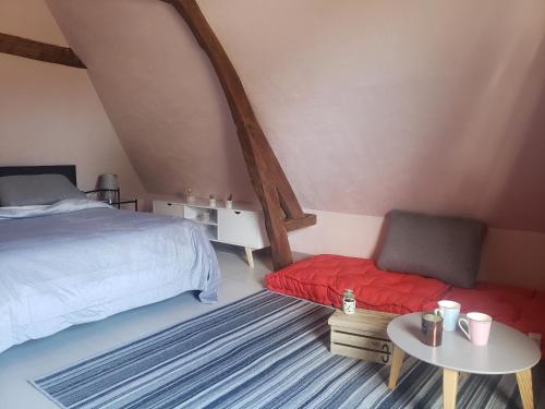 ein Schlafzimmer mit einem Bett, einem Tisch und einem Stuhl in der Unterkunft LA PAGODE in Osmoy-Saint-Valery