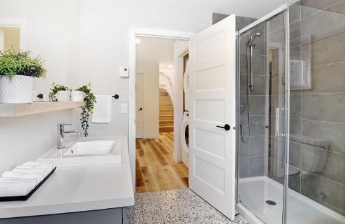 a white bathroom with a shower and a sink at 13 Chemin des Cascades in Stoneham