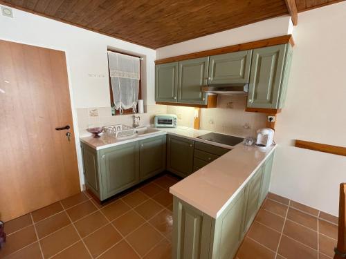 a kitchen with green cabinets and a sink at Hundefreundliche Bergwohnung neben der Skipiste - Mittelstation Skigebiet Gerlitzen in Kanzelhöhe